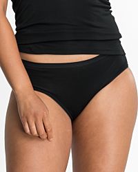 Model trägt Hüftslip in schwarz aus der Serie Nadine, Ansicht von vorne.