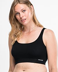 Model trägt Trägerbustier in schwarz aus der Serie Bio Cotton, Ansicht von vorne.