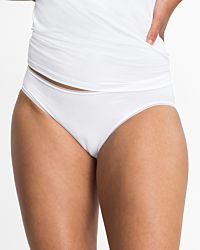 Model trägt Minislip in weiß aus der Serie Magic look, Ansicht von vorne.