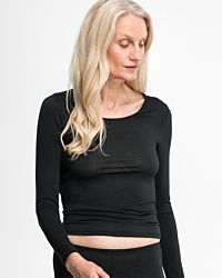Model trägt Shirt 1/1 Arm in schwarz aus der Serie Sanja, Ansicht von vorne.