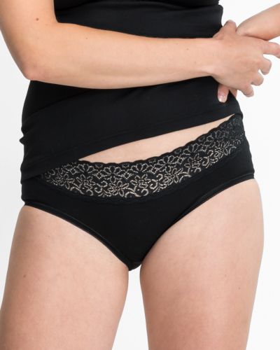 Model trägt Hüftslip in schwarz aus der Serie Natalie, Ansicht von vorne.