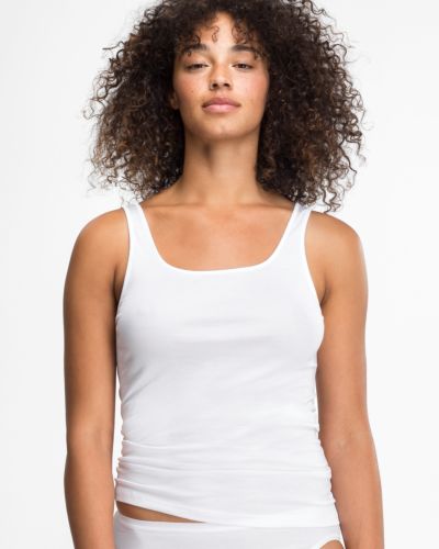 Model trägt Achselhemd in weiß aus der Serie Nadine, Ansicht von vorne.