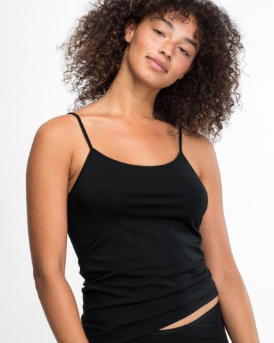 Model trägt Spaghettitop in schwarz aus der Serie Natural Beauty, Ansicht von vorne.