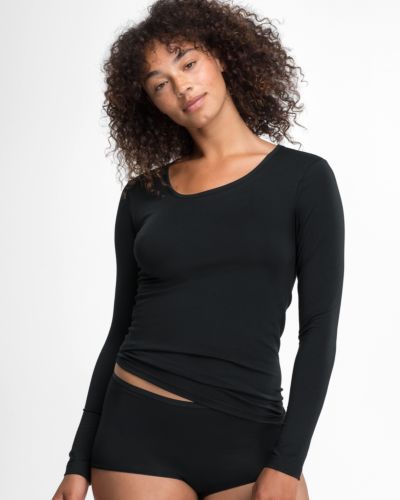 Model trägt Shirt 1/1 Arm in schwarz aus der Serie Natural Beauty, Ansicht von vorne.