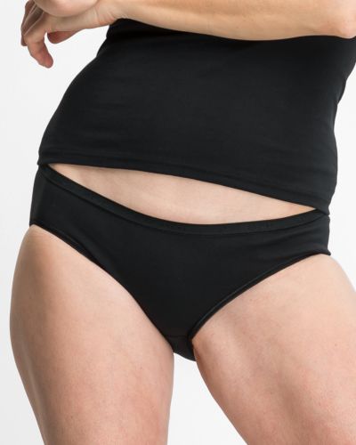 Model trägt Minislip in schwarz aus der Serie Silke, Ansicht von vorne.