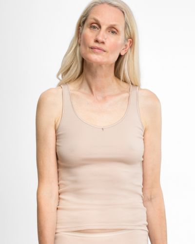 Model trägt Achselhemd in honey aus der Serie Silke, Ansicht von vorne.