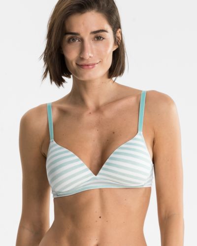 Model trägt Schalen BH Triangle in minze / off white aus der Serie Regina, Ansicht von vorne.