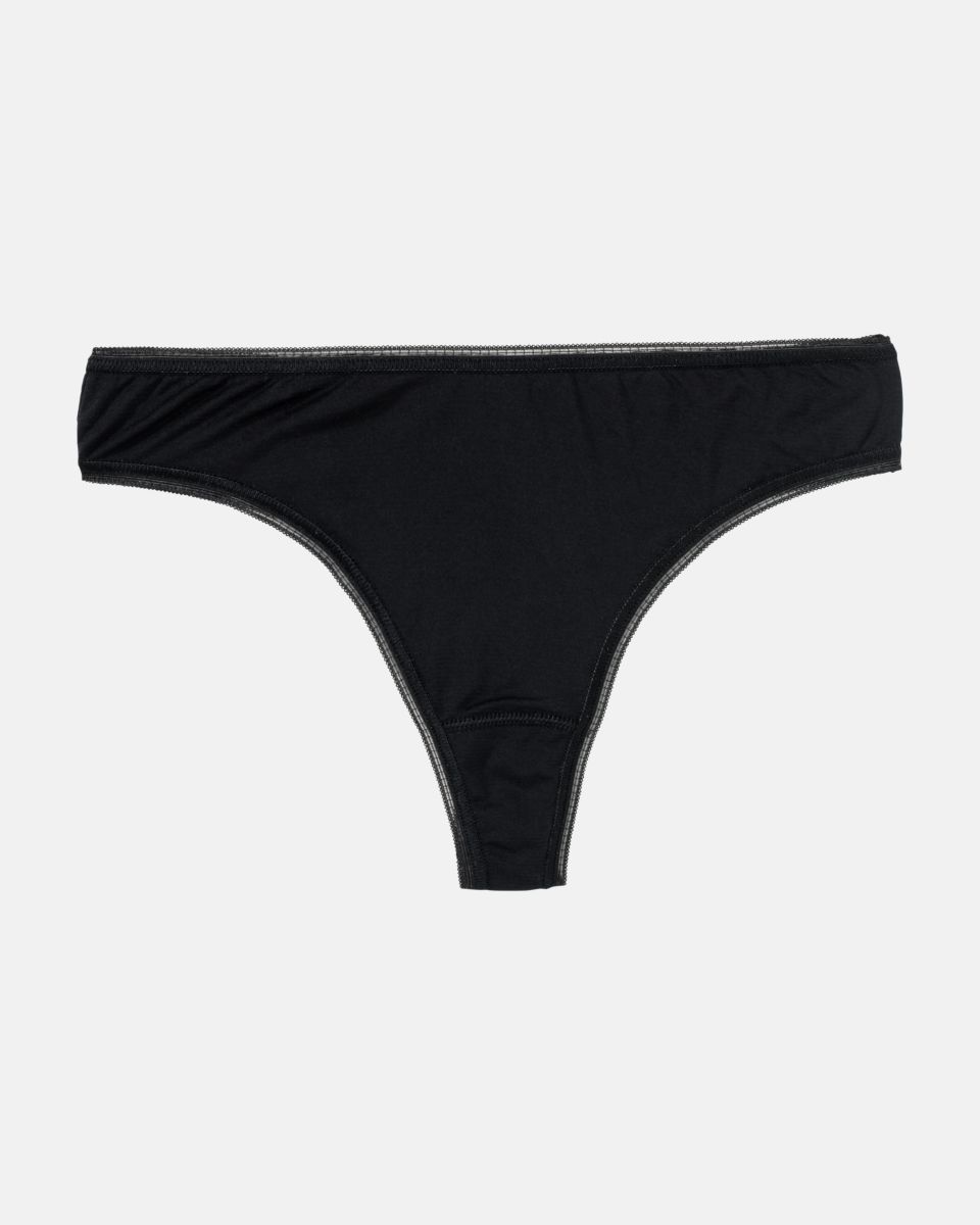 String Tanga in schwarz aus der Serie Magic look, flach auf einer Oberfläche liegend.